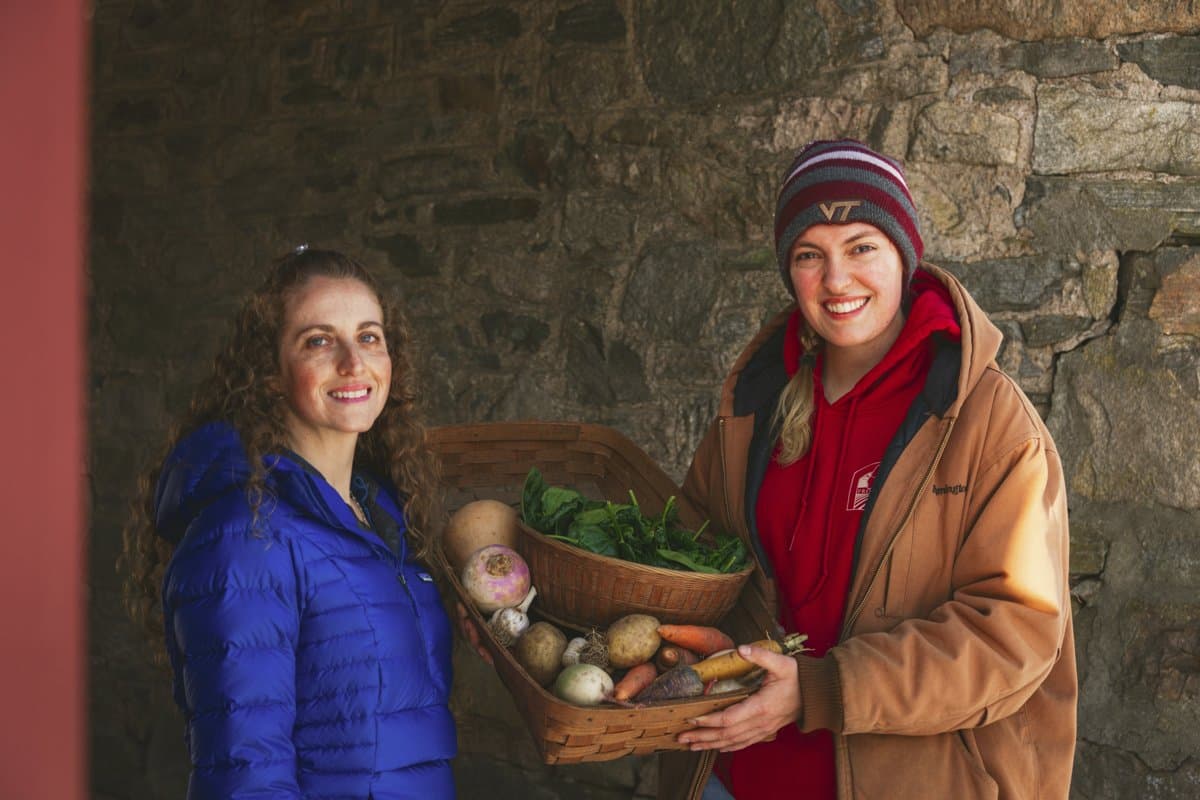 Two Healthy PlanEat supporters holding a basket of fresh local produce